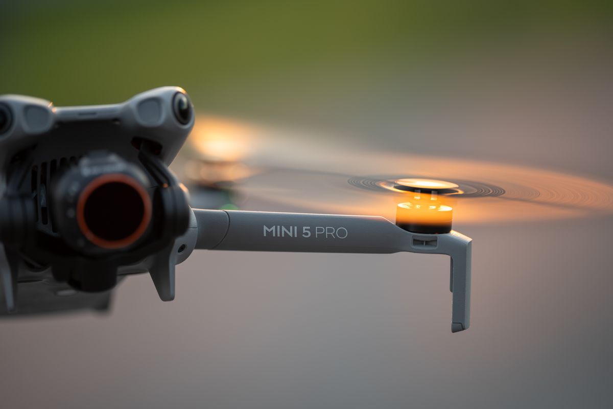 Close detail of the DJI Mini 5 Pro airframe arm and rotor with ND filter fitted